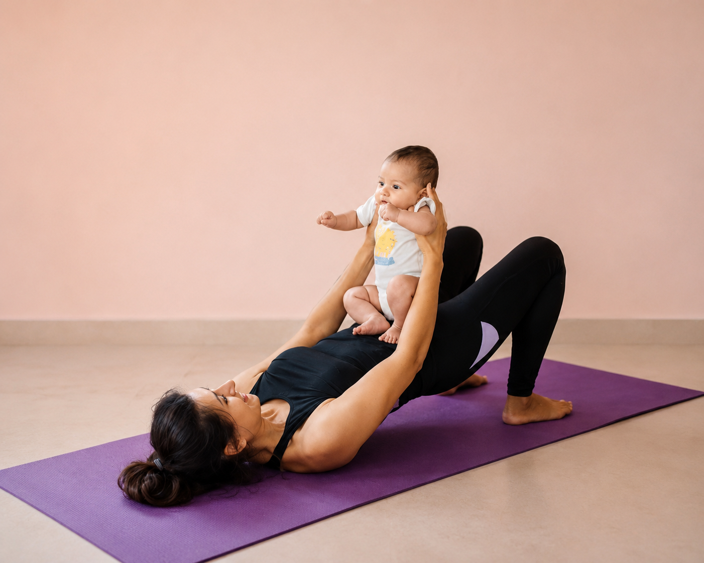 Woman doing a bridge exercise on a mat while holding her baby