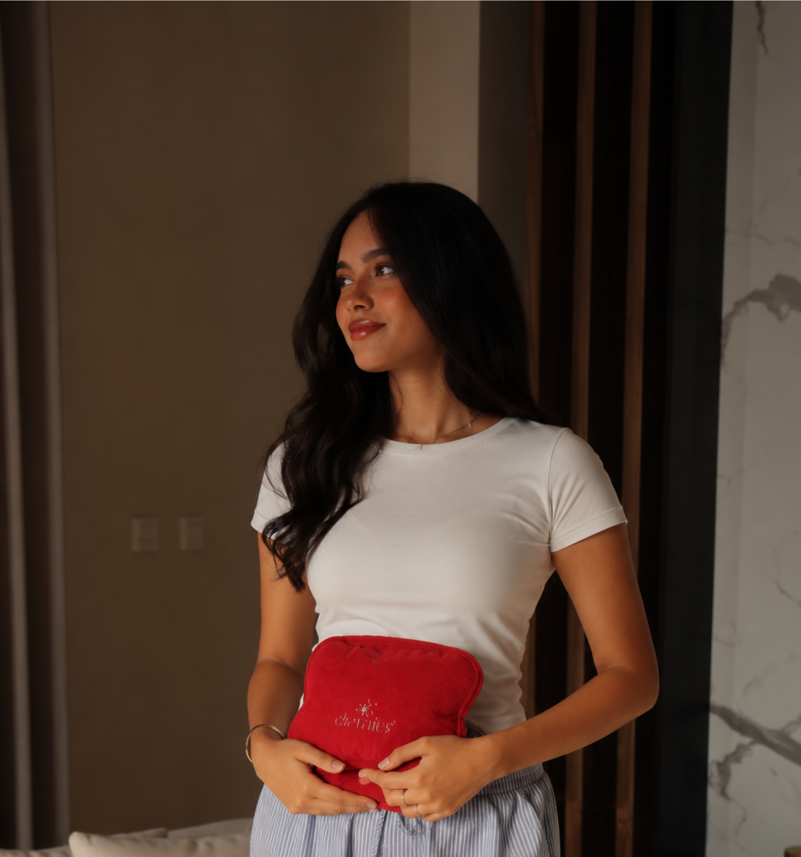 Woman using a heating pad — period care that works with your body